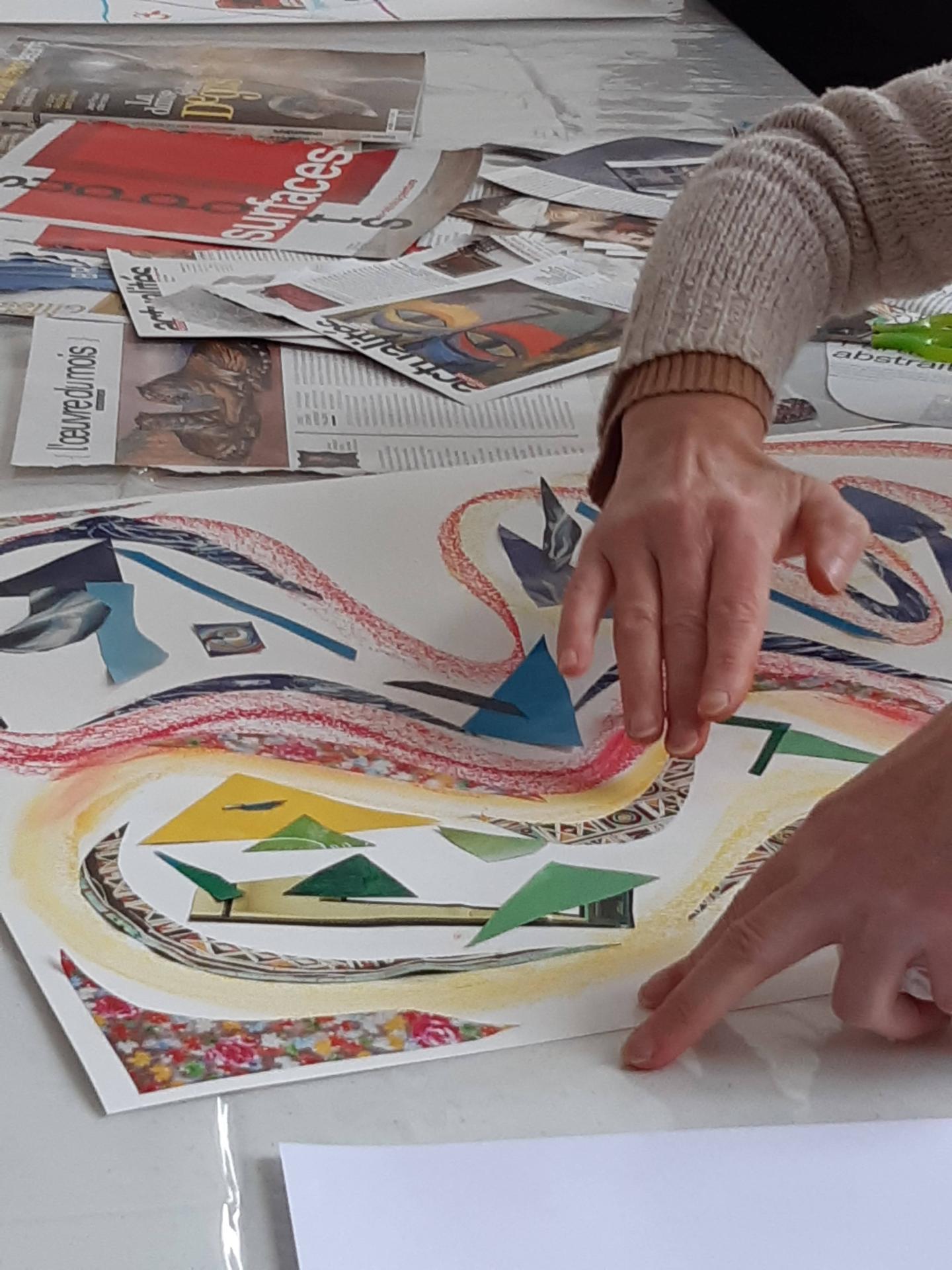 Mains qui assemblent un collage de papiers découpés pendant une séance individuelle
