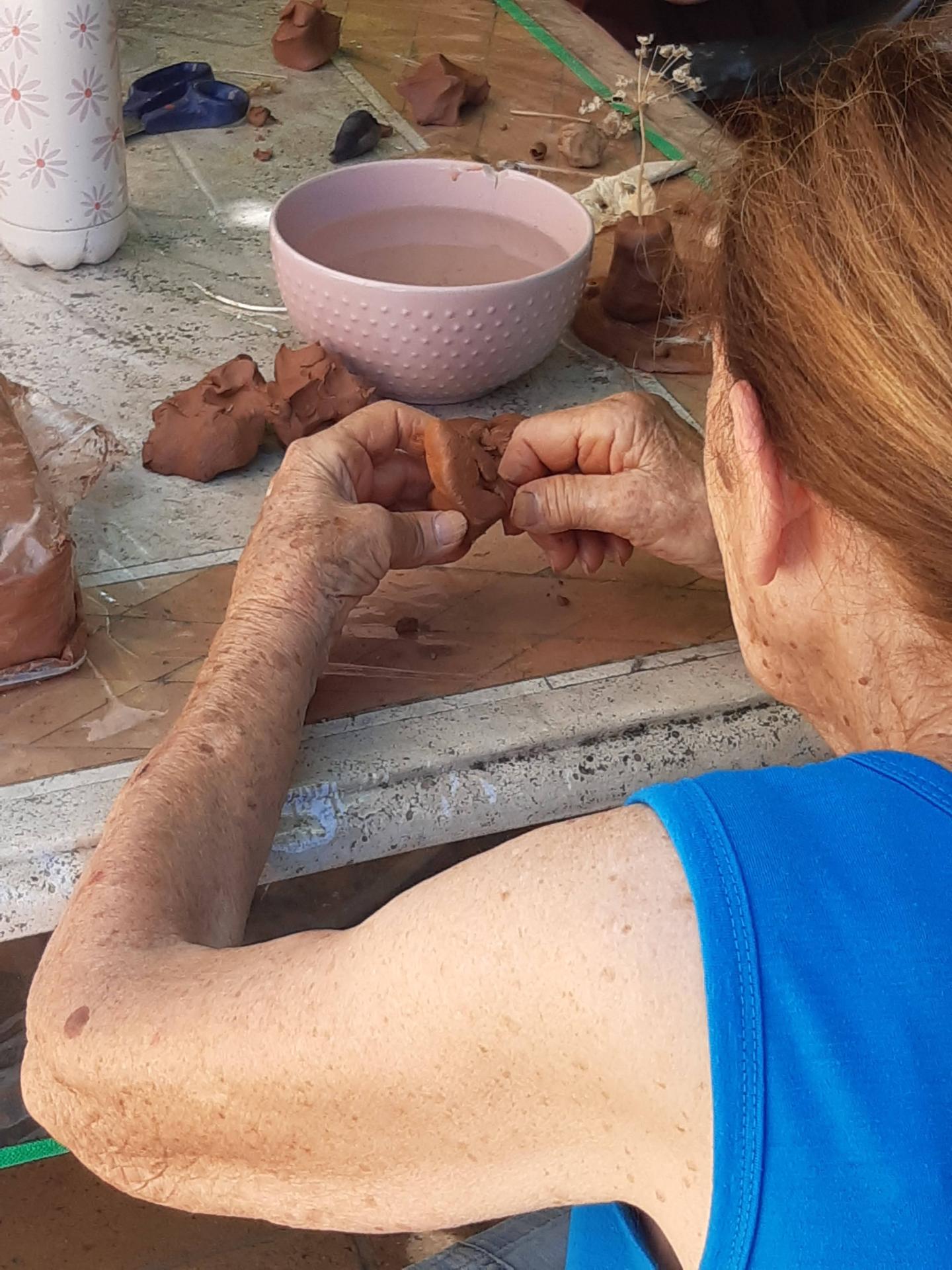 Une participante modèle l'argile à pleines mains pendant un atelier d'art-thérapie